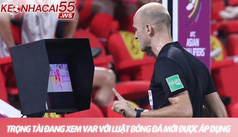 Trọng tài đang xem lại VAR với những luật bóng đá mới được áp dụng
